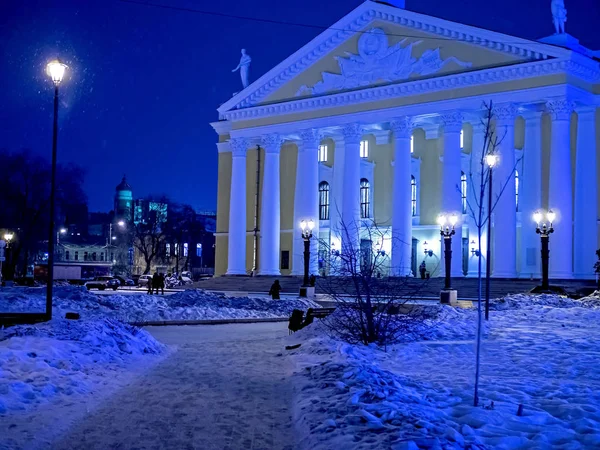 Огни города оформлены в античном стиле в зимнюю ночь во время снегопада возле Оперного театра в Челябинске — стоковое фото