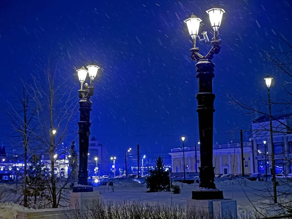 Городские фонари, оформленные в старинном стиле в зимнюю ночь во время снегопада — стоковое фото