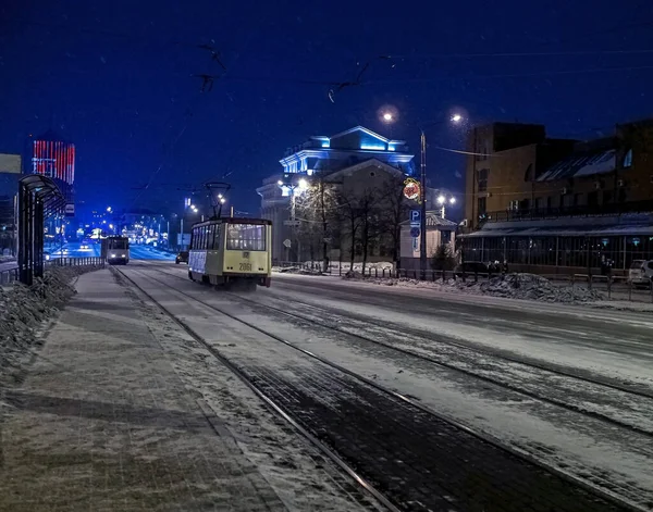 Bondes viajam ao longo da rua noturna de inverno de Kirov durante uma queda de neve em Chelyabinsk — Fotografia de Stock