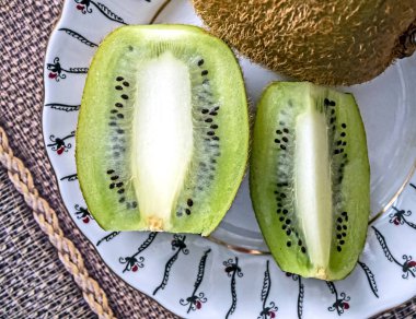 Olgun kivi bir tabakta parçalara bölünmüş.