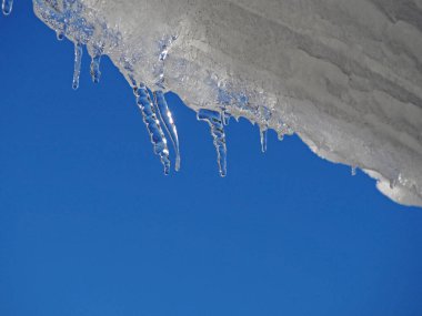 Mavi gökyüzüne karşı küçük buz saçakları