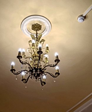Oda tiyatrosunun girişinde bir avize ve tavanda bir yangın güvenlik sensörü.