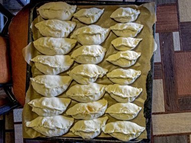 Çarşaftaki turtalar fırında pişirilmeye hazırdır.