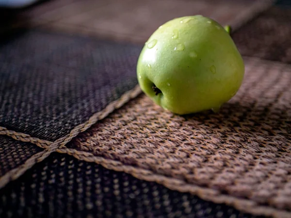 Grüner Apfel Auf Dem Tisch Mit Wassertropfen Die Vom Licht — Stockfoto