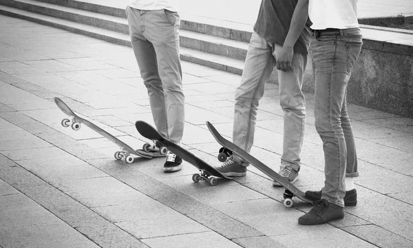 Group of skateboarders are standing near their boards