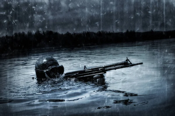 Military diver emerges from under the water and takes aim from t