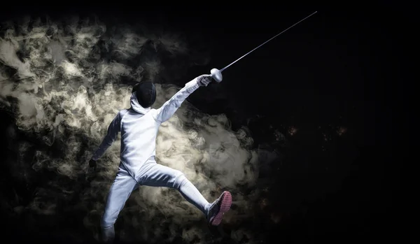 The fencer moves forward with a sword in his hand. Sport concept. Mixed media