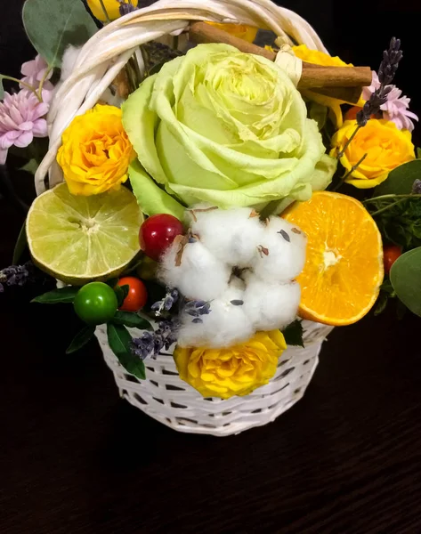 Composition of flowers and fruits. Bouquet on a dark background