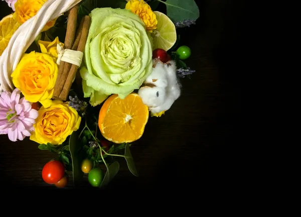 Composition of flowers and fruits. Bouquet on a dark background
