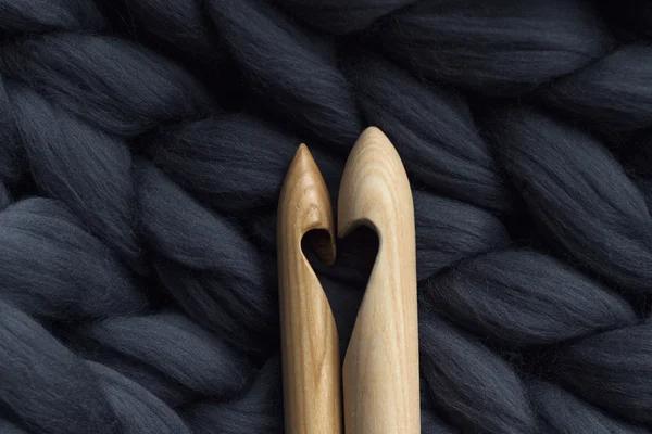 Aiguilles à tricoter en bois sur fond de laine mérinos grise blanke — Photo