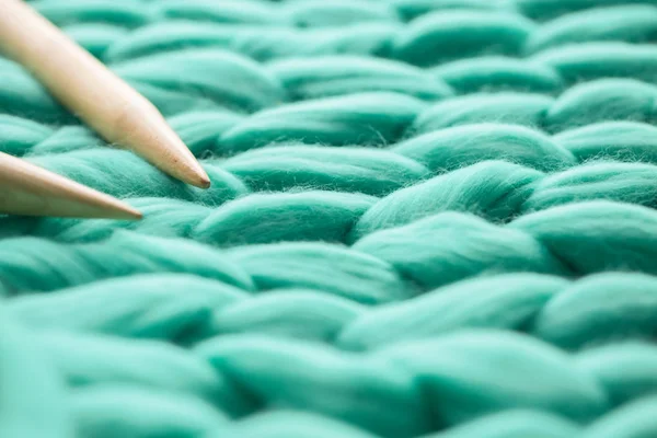 Wooden knitting needles on background of merino wool blanket — Stock Photo, Image