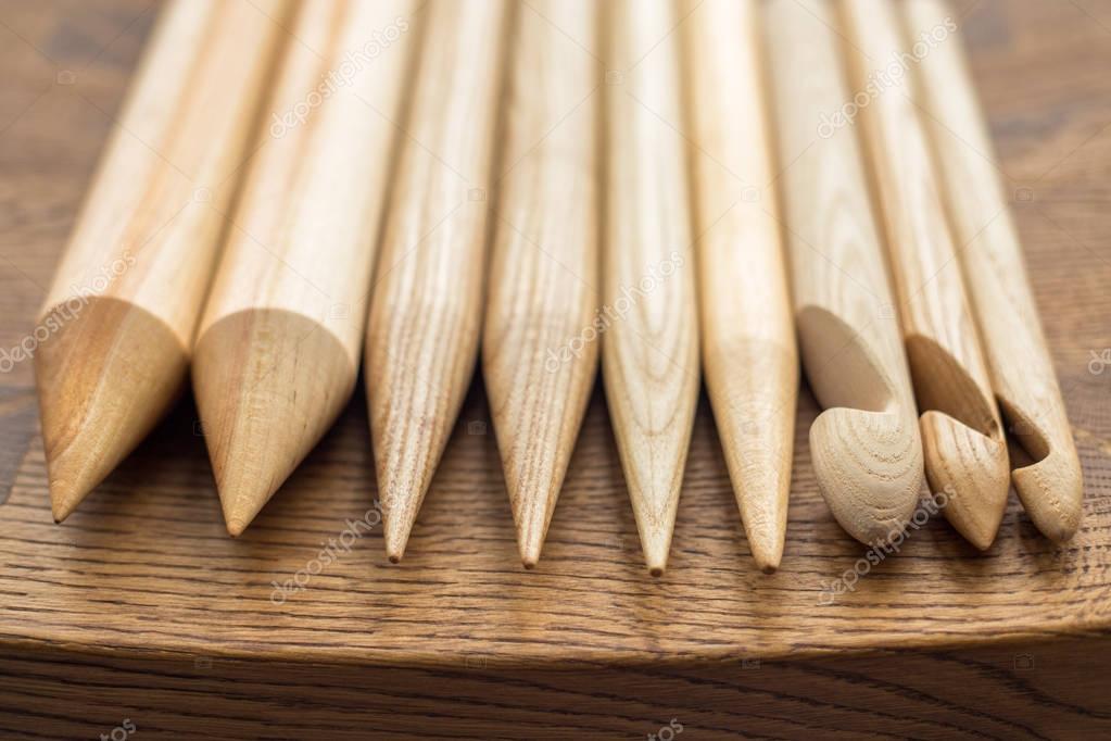 Wooden knitting needles on wooden table Stock Photo by ©riakhinstock  129141152