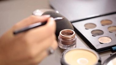 Küçük makyaj fırça kahverengi göz gölgeler üzerinde hareket yakın çekim