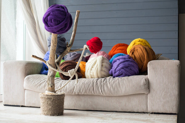 Warm interior with merino wool balls in multicolour on white sof
