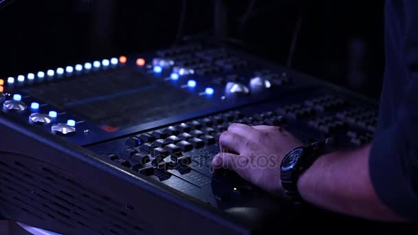 Mano del productor de sonido en el panel del mezclador, trabajando en el mezclador de audio — Vídeo de stock