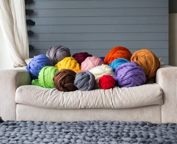 Мериносовые шерстяные шарики в разноцветном лежа на белом диване с мериносом — стоковое фото