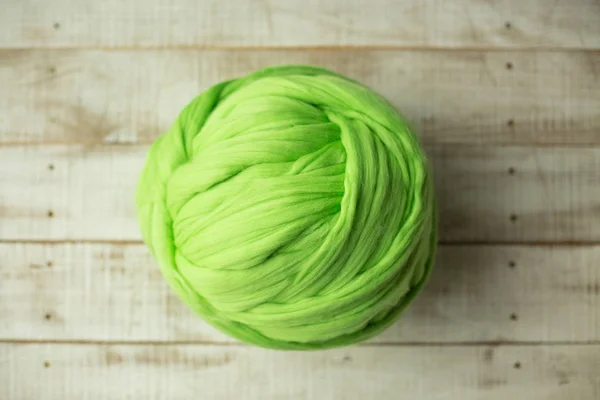 Bola de lã merino verde no fundo de madeira — Fotografia de Stock