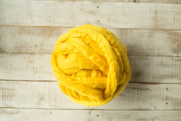 Κίτρινο μερινός μαλλί μπάλα σε φόντο ξύλινη — Φωτογραφία Αρχείου
