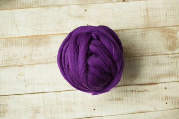 Bola de lã merino roxo no fundo de madeira — Fotografia de Stock