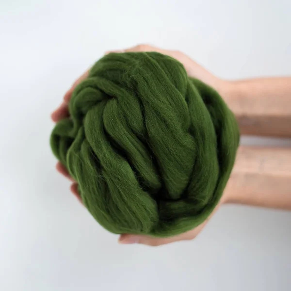 Close-up de bola de lã de merino verde em mãos — Fotografia de Stock