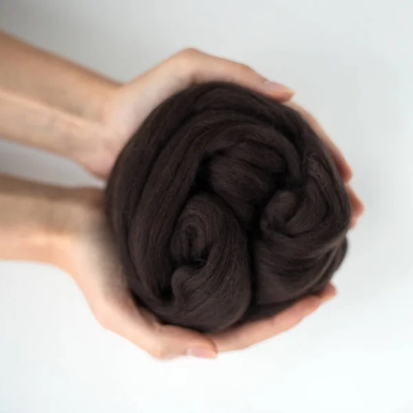 Close-up de bola de lã de merino preto em mãos — Fotografia de Stock