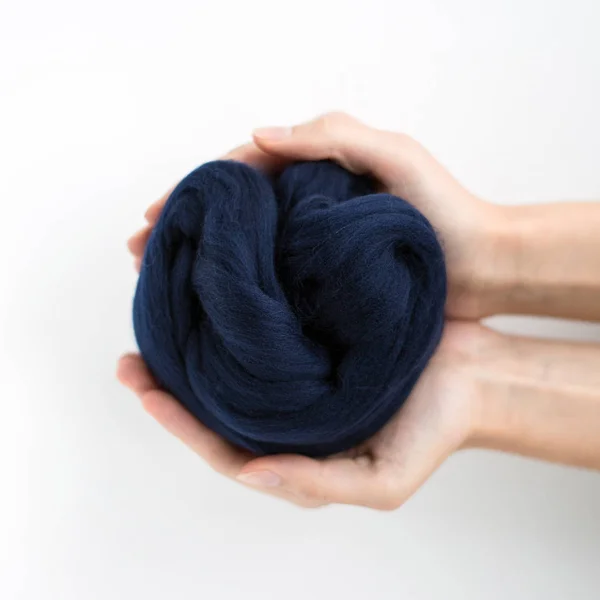 Close-up van blauwe merino wol bal in handen — Stockfoto