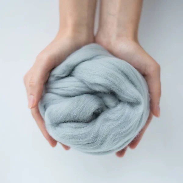 Close-up of light grey merino wool ball in hands — Stock Photo, Image