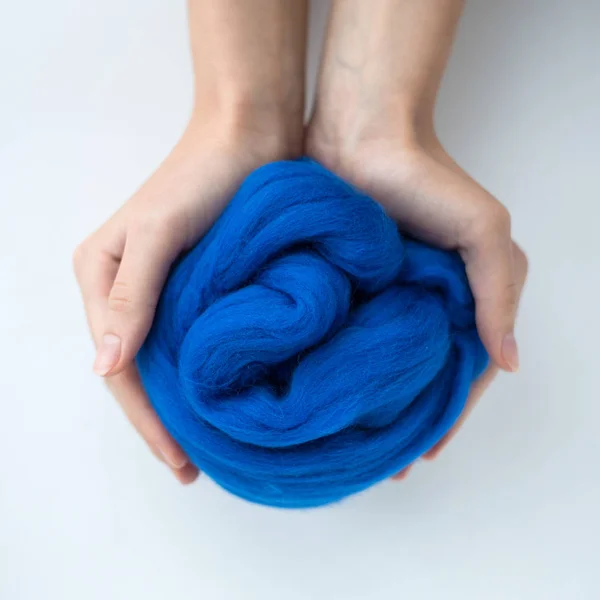 Nahaufnahme eines blauen Merinowollknäuels in Händen — Stockfoto