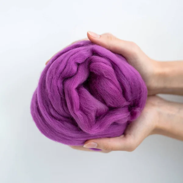 Close-up de bola de lã de merino violeta em mãos — Fotografia de Stock