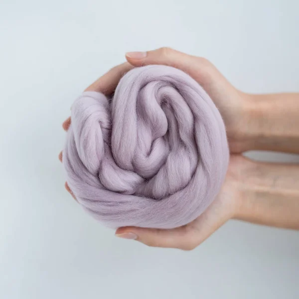 Close-up de bola de lã de merino violeta em mãos — Fotografia de Stock