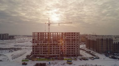 Yapım aşamasında günbatımında bir kış gününde büyük apartman binaları