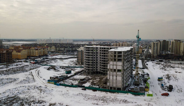 Large apartment buildings under construction on a winter day at sunset