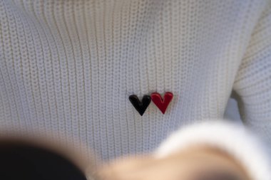 Kalp, örgü süveter arka planında. Kalp kırmızıya boyanmış.