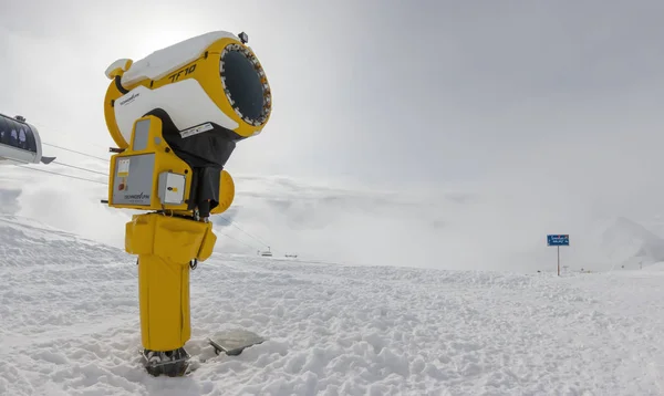 Canon à neige dans une station de ski sur un fond de montagnes dans les nuages et une gondole — Photo