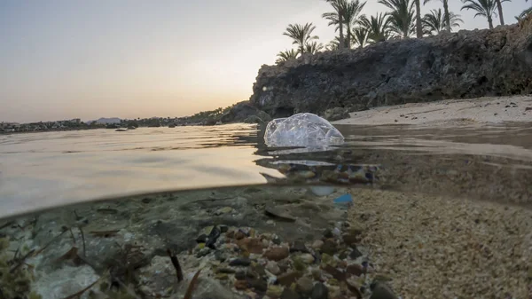 Botella de basura de plástico en la contaminación del agua. Fotos submarinas de tiro partido —  Fotos de Stock