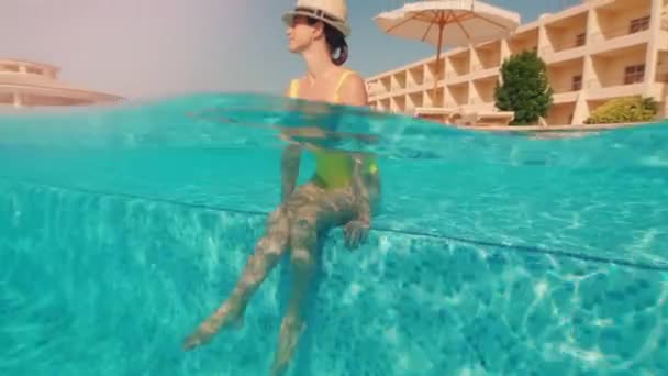 美丽性感的年轻微笑的女人在夏天的游泳池海滩 女孩在阳光明媚的日子在热带游泳池里放松 用脚泼洒水 用温泉 水下分裂 — 图库视频影像
