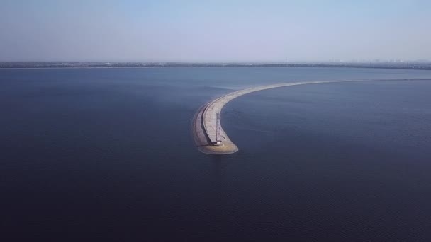 Vue de dessus de la jetée du comté avec un phare sur lequel nichent les goélands volant dessus et les goélands tournant autour à proximité 