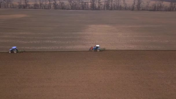 在两个拖拉机的田里沿着犁沟线飞行 在田里干活和犁地 — 图库视频影像