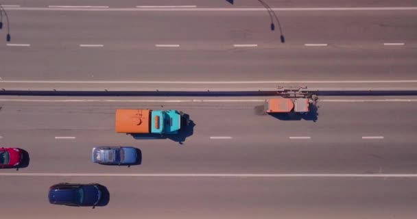 Een gespecialiseerde auto reinigt de weg, auto 's rijden rond op een zonnige dag — Stockvideo