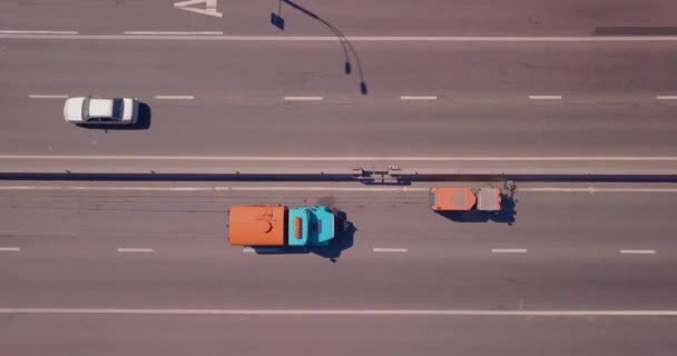 Ένα εξειδικευμένο αυτοκίνητο καθαρίζει την άκρη του δρόμου, τα αυτοκίνητα πηγαίνουν γύρω σε μια ηλιόλουστη μέρα — Αρχείο Βίντεο