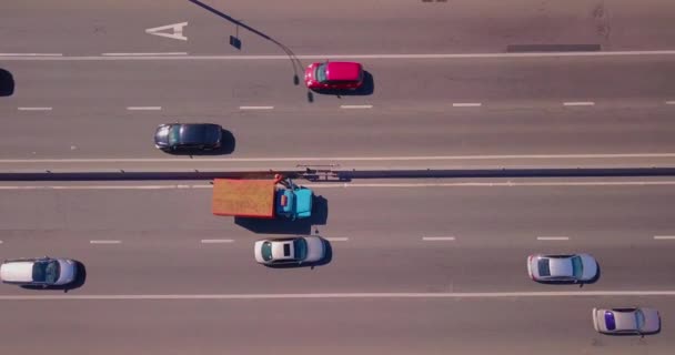 Ένα εξειδικευμένο αυτοκίνητο καθαρίζει την άκρη του δρόμου, τα αυτοκίνητα πηγαίνουν γύρω σε μια ηλιόλουστη μέρα — Αρχείο Βίντεο