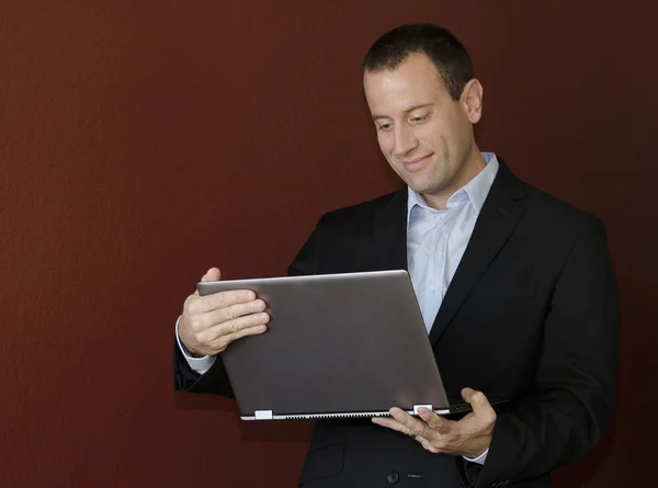 bir dizüstü bilgisayar ile çalışan adam.