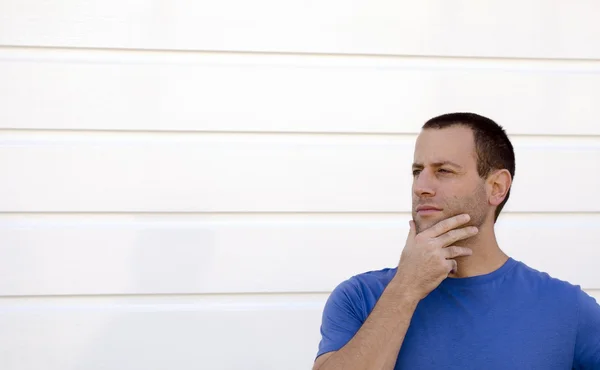 Mann mit der Hand im Gesicht denkt an das, was morgen kommen wird. Stockbild