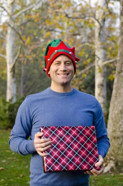 Bir Noel şapka hediye tutan adam.