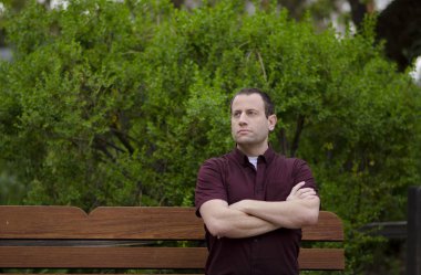 Bir bankta oturan iyimser adam.