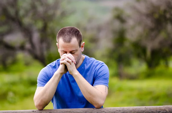 Člověk se modlí s jeho hlavou dolů venku v přírodě. — Stock fotografie