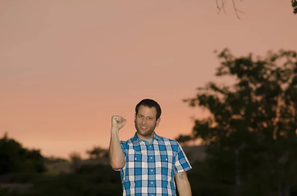 Kızgın adam açık havada bir yumruk ile alacakaranlıkta..