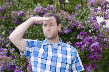 Alnındaki el ile bakan adam.