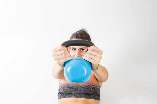 Beyaz arka plan üzerinde kettlebell ile egzersiz kız