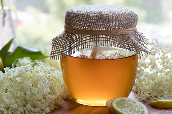 Un frasco de miel y flores de saúco, listo para hacer un jarabe — Foto de Stock